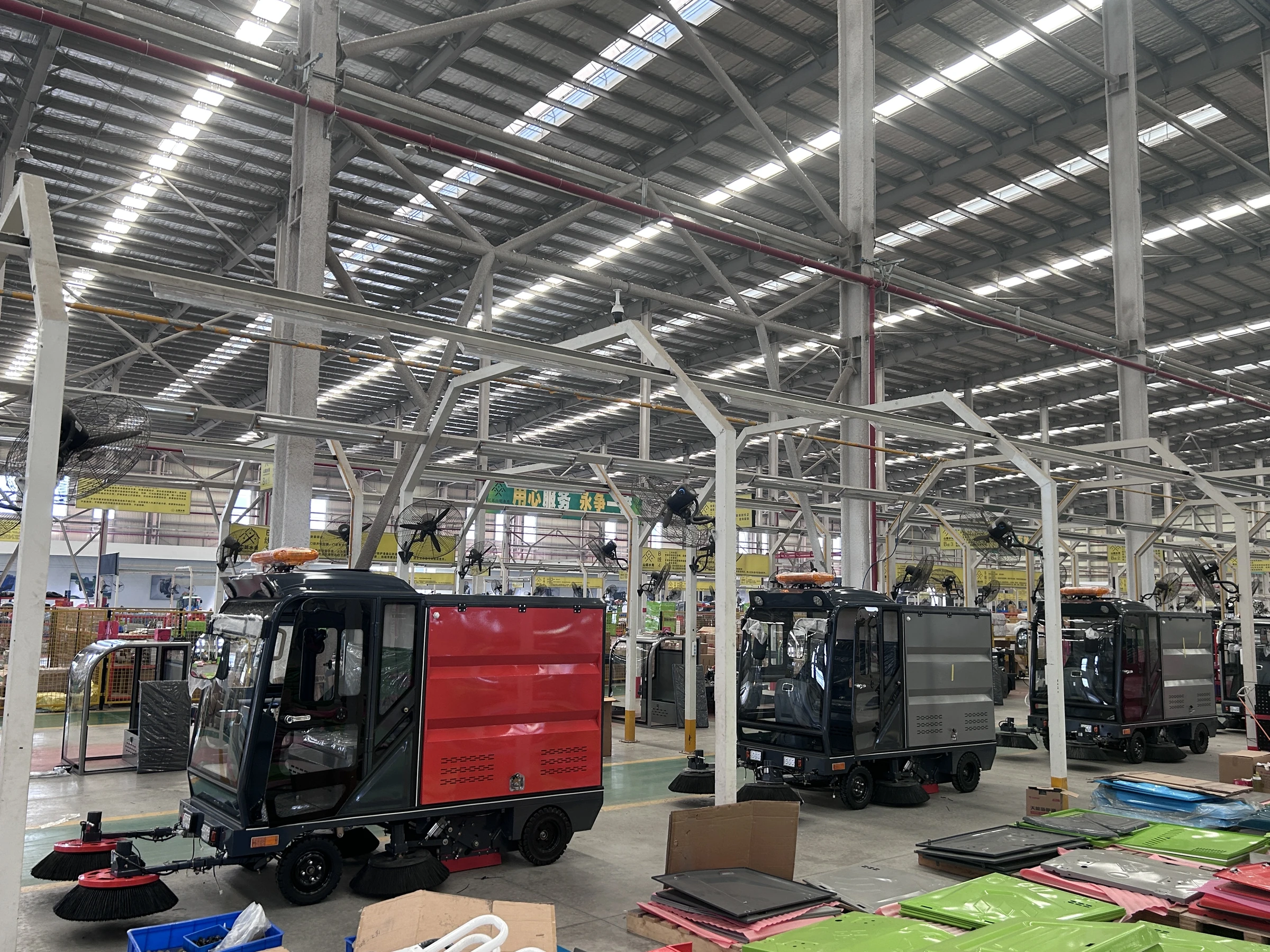 Electric sweepers moving through the production workshop